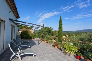 a patio with chairs and plants on a balcony at Chez Sylvain in Carcès