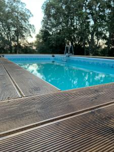 a blue swimming pool with a wooden deck at Casa La Liccia in Calangianus