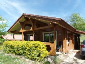 a log cabin with a car parked in front of it at Chalet le Chal'Heureux in Mauroux