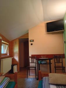 a room with a table and a television on the wall at Chalupa Mlyn Dolný Kubín in Dolný Kubín