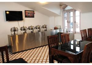 a restaurant with a table and a stainless steel counter at hotel the kannaz in Srinagar