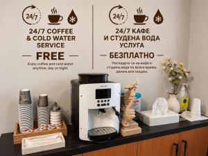 a coffee and cold water service sign on a counter at Enza Suites in Shumen