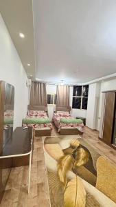 a room with two beds and a glass table at Fadi house in Abū Kabīr