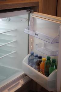 an open refrigerator filled with bottles of juice at Studio Henigman in Dolenja Vas