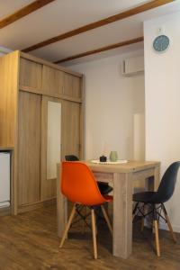 a dining room with a wooden table and chairs at Studio Henigman in Dolenja Vas