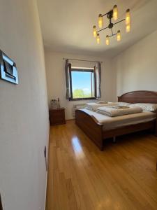 a bedroom with a bed and a window and wooden floors at Casa Fortunata in Kaštel