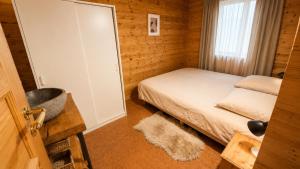 a small bedroom with a bed and a mirror at Chalet le Chal'Heureux in Mauroux +18 photos