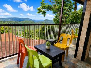 a table and chairs on a balcony with a view at Garbat valley view Matheran in Matheran