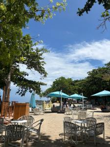a group of tables and chairs with umbrellas at Ocean View Corner Studio Private Balcony Tambuli Tower F in Maribago