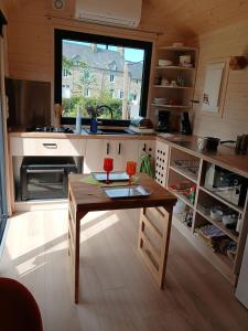 a kitchen with a wooden table and a large window at entre bourg et rivage in Saint-Pierre-Langers +9 photos