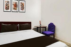 a bedroom with a bed and a chair and a table at Hotel O Akash Namostay in Jamshedpur