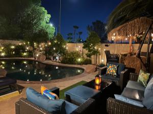 a patio with chairs and a pool at night at Amazing Grace Vacation Home in Las Vegas