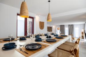 a dining room with a large white table with chairs at Antiparos Gems - The villa in Antiparos
