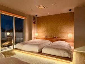 a bedroom with a large white bed and a window at Grand Opening SORA Yunokawa Penthouse in Hakodate