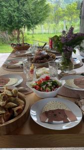 a wooden table with plates of food on it at HERC domaćinstvo in Nova Varoš