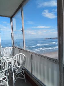 a balcony with chairs and a table and a view of the beach at salinas playa in Salinas