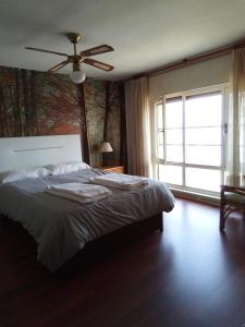 a bedroom with a bed with a ceiling fan and a window at salinas playa in Salinas