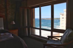 a bedroom with a window looking out at the ocean at salinas playa in Salinas