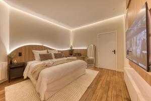 a large bedroom with a large bed and a tv at Suite Prestige Spa Privatif D'exception in LʼIsle-Adam +26 photos