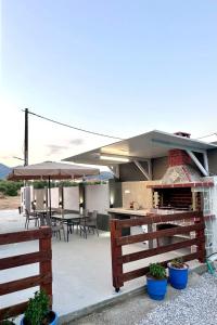 a patio with a grill and tables and an umbrella at Mimoza Apartments in Limenaria