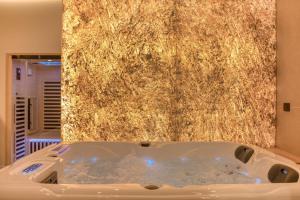 a bath tub in a bathroom with a stone wall at Suite Prestige Spa Privatif D'exception in LʼIsle-Adam