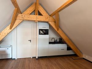 a kitchen with white cabinets and a vaulted ceiling at Charmant studio climatisé Kintzheim in Kintzheim