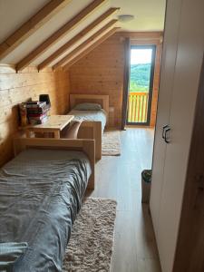 a bedroom with two beds and a desk and a window at Apartman Andrej in Kolarec