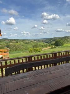 a wooden bench with a view of the countryside at Apartman Andrej in Kolarec