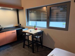 a small kitchen with a table and a window at Charmant studio climatisé Kintzheim in Kintzheim +2 photos