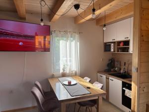 a kitchen with a dining table and a tv on the wall at Apartman Andrej in Kolarec