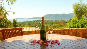 a bottle of wine and two glasses on a wooden table at Royal Palm in Porto-Vecchio