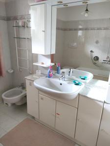 a bathroom with a sink and a toilet at Villa Cares - Pension mit Tischtennis in Cares +16 photos