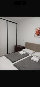 ein Zimmer mit einem Bett und einem Bild an der Wand in der Unterkunft Central Square in Tuzla