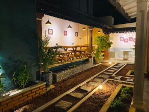 an outdoor patio with a table and benches at night at Thisu Villa in Dickwella