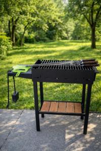a barbecue grill with tongs on it in a park at Woodside House in Solotvyno