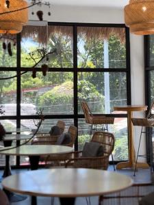 a room with tables and chairs and a large window at Poddwell Siquijor in San Juan