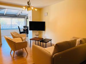 a living room with a couch and chairs and a flat screen tv at L'Accalmie - Résidence calme, Plein centre, Plain pied in Crest