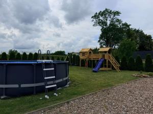 a playground with a slide and a house at Mazurskie El Dorado in Mikołajki +10 photos