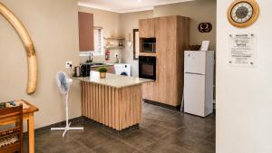a kitchen with a counter and a white refrigerator at Lloyds - unit 10 in Ermelo