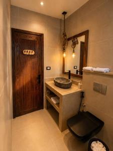 a bathroom with a sink and a wooden door at Isis Dahab in Dahab