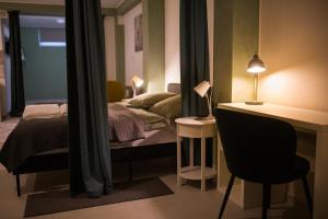 a bedroom with a bed and a desk with a chair at Da Vinci Apartmanok in Eger