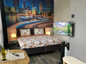 a bedroom with a bed with a painting on the wall at B&B DownUnder in Vlissingen