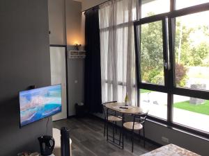 a living room with a table and a large window at B&B DownUnder in Vlissingen