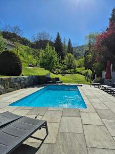 a swimming pool in a yard with a patio at Haus Hees - Urlaub im Gletscherkessel Präg in Todtnau