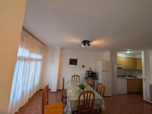 a dining room with a table and chairs and a kitchen at Casa Doro in Escalona