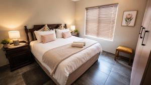 a bedroom with a large bed and a window at Lloyds - unit 10 in Ermelo