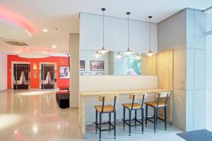 a kitchen with three bar stools and a counter at Red Planet Ortigas in Manila