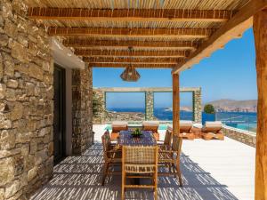 a patio with a table and chairs on a stone wall at Vinara Luxury Suites Mykonos in Mykonos