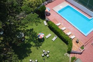 an overhead view of a pool with chairs and an umbrella at Gran Hotel Nortomarza in La Falda