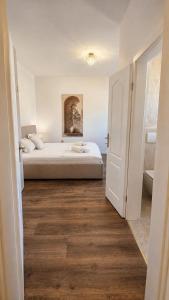 a white bedroom with a bed and a bathroom at Villa Olivia in Banjole